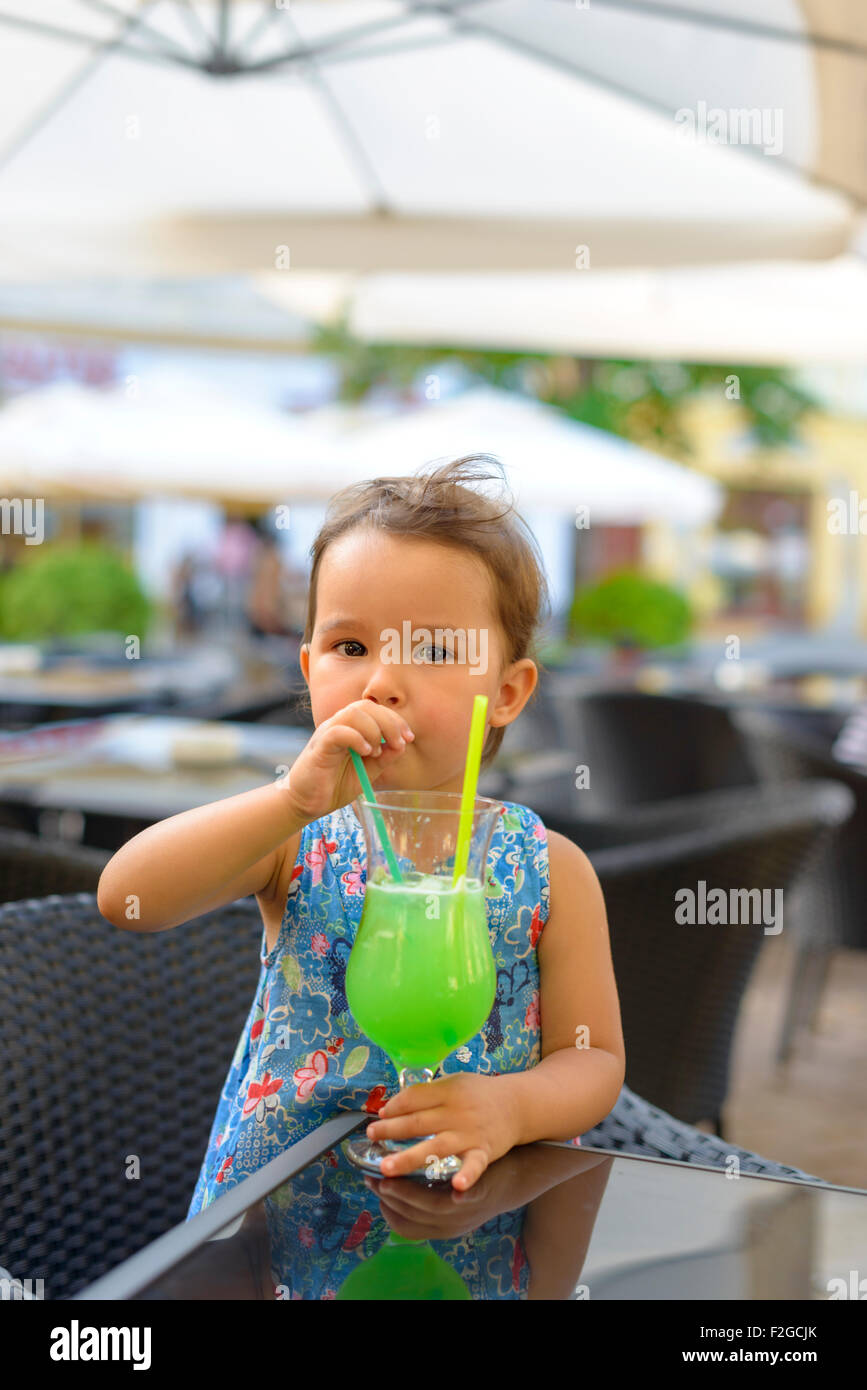 Little girl is drinking  lemonade with mint using straw Stock Photo