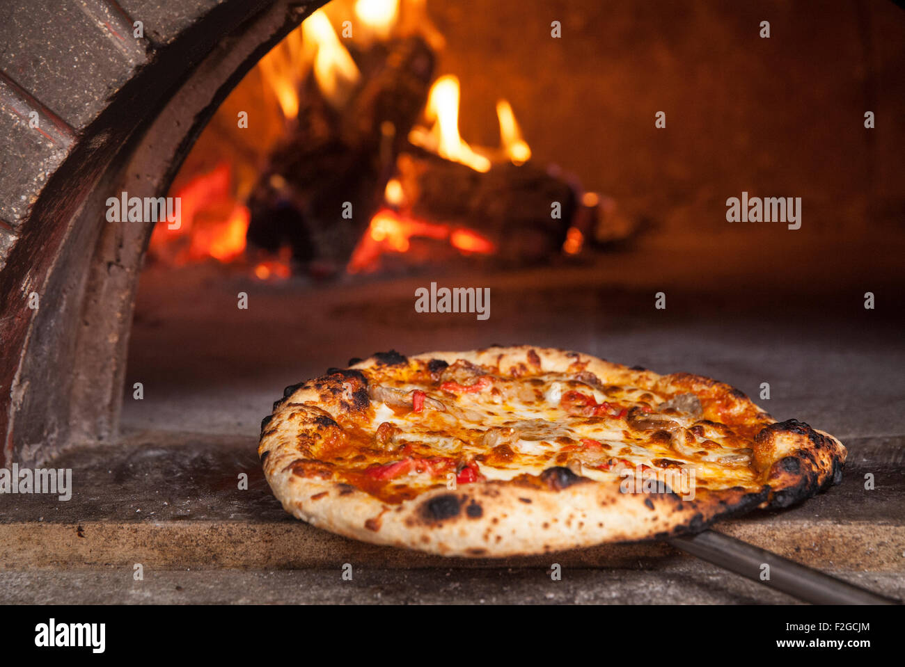cheese pizza at the front of a wood burning pizza oven Stock Photo