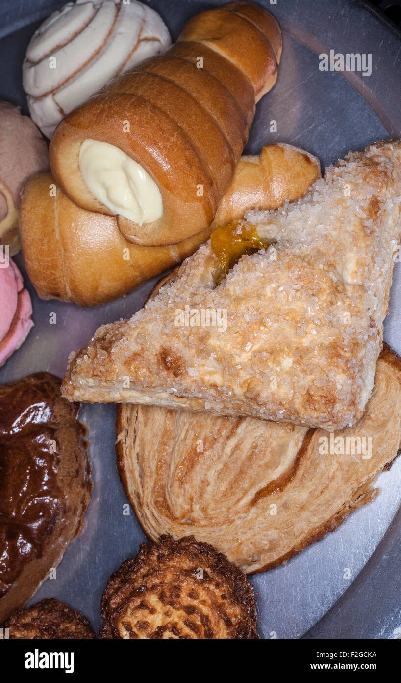 vertical photograph of various Mexican pastries on round metal tray Stock Photo