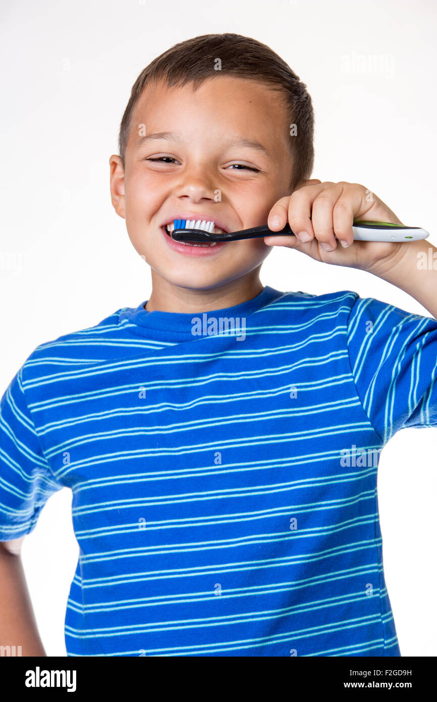 Boy brushing teeth - isolated white background. Stock Photo