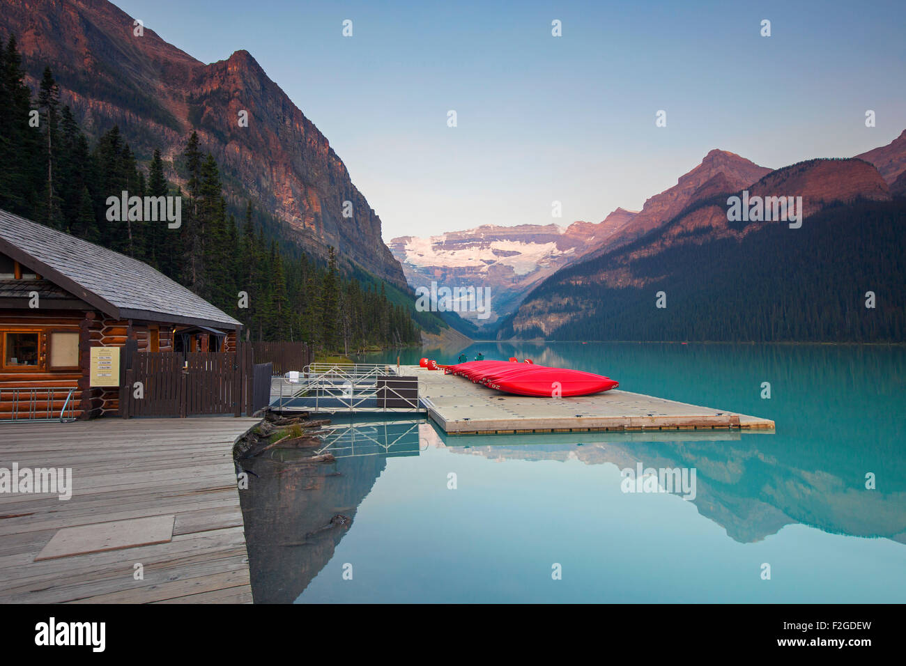 Red canoes at glacial Lake Louise with Victoria glacier, Banff National Park, Alberta, Canada Stock Photo