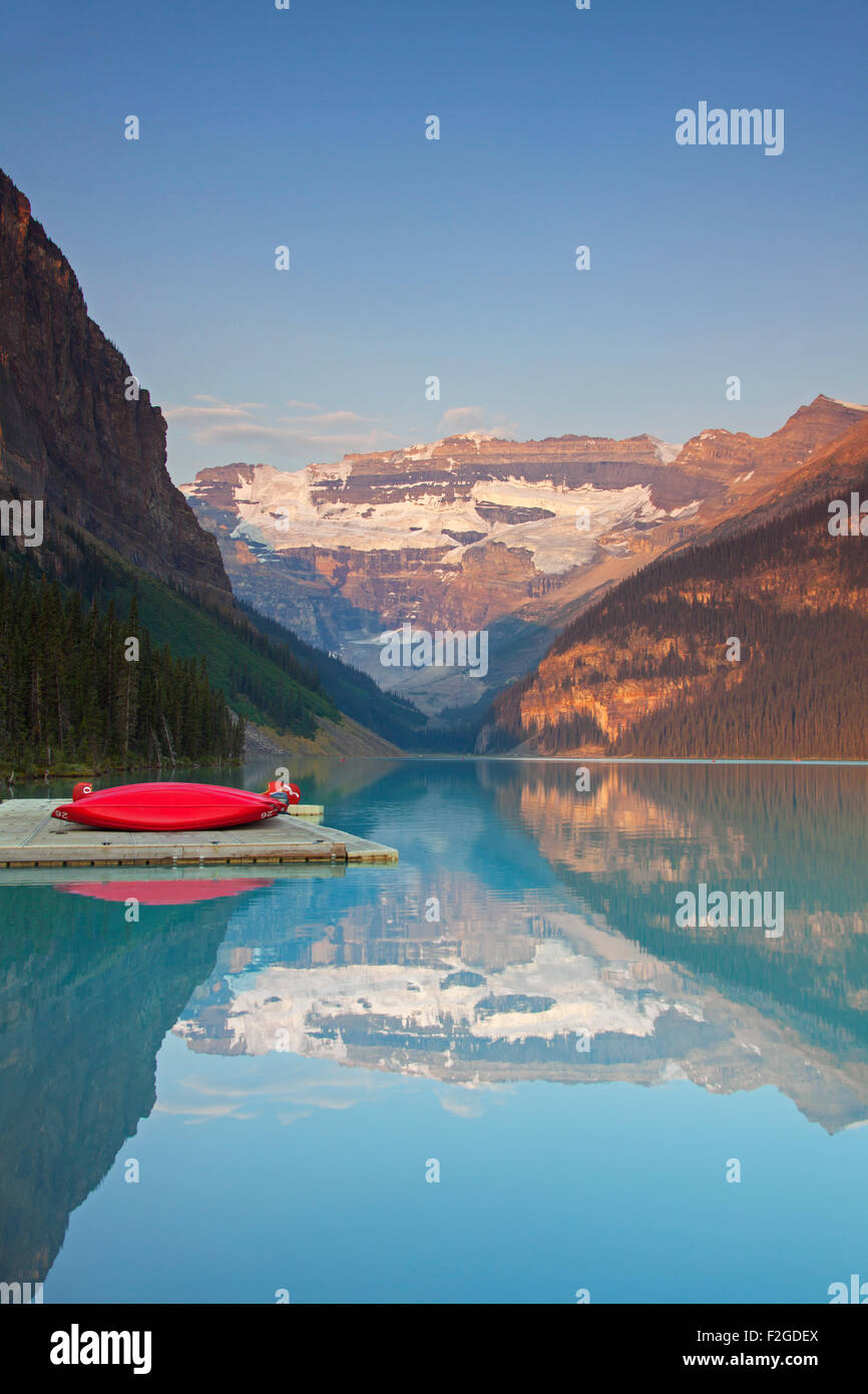 Red canoes at glacial Lake Louise with Victoria glacier, Banff National Park, Alberta, Canada Stock Photo