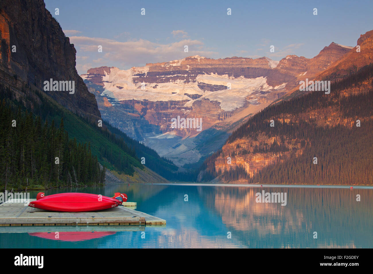 Red canoes at glacial Lake Louise with Victoria glacier, Banff National Park, Alberta, Canada Stock Photo