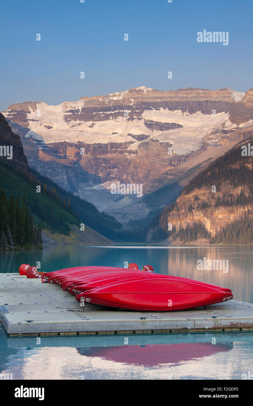 Red canoes at glacial Lake Louise with Victoria glacier, Banff National Park, Alberta, Canada Stock Photo