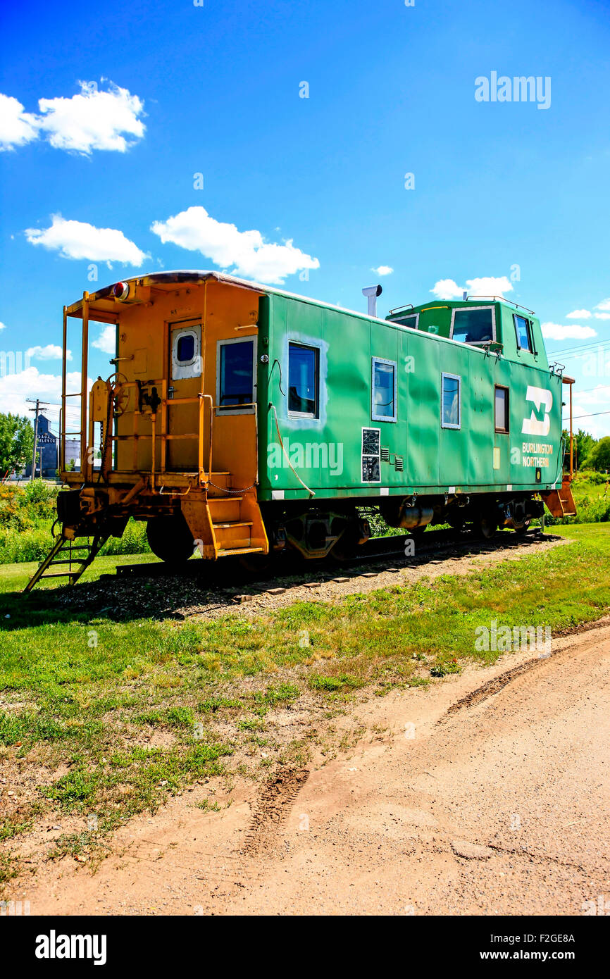 A green and Yellow painted railroad caboose at the Montana Centennial Train Museum in Wibaux MT Stock Photo