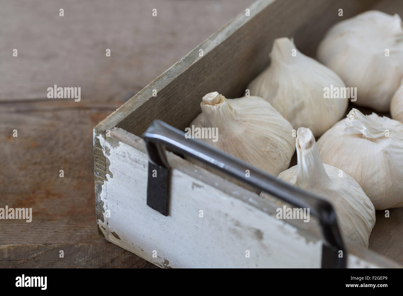Garlic bulbs in a rustic wooden box on a wooden table Stock Photo - Alamy