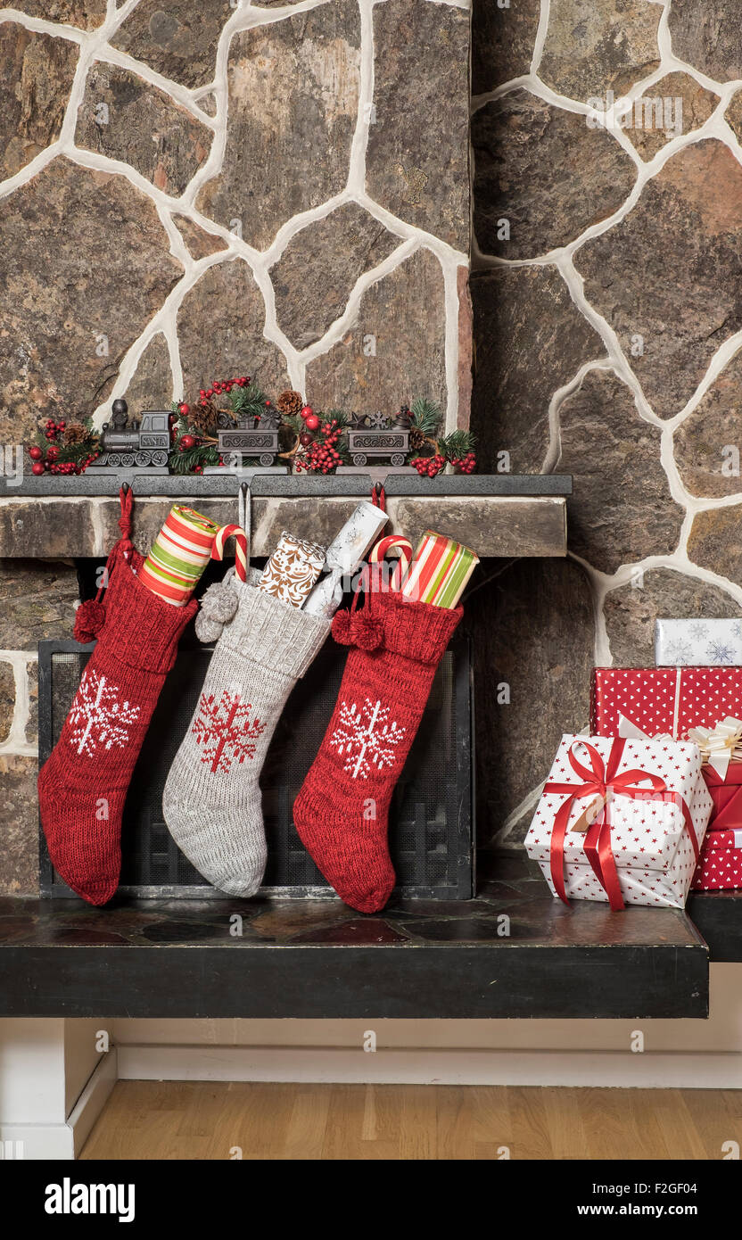 Stuffed stockings hanging on a fireplace on christmas morning Stock Photo