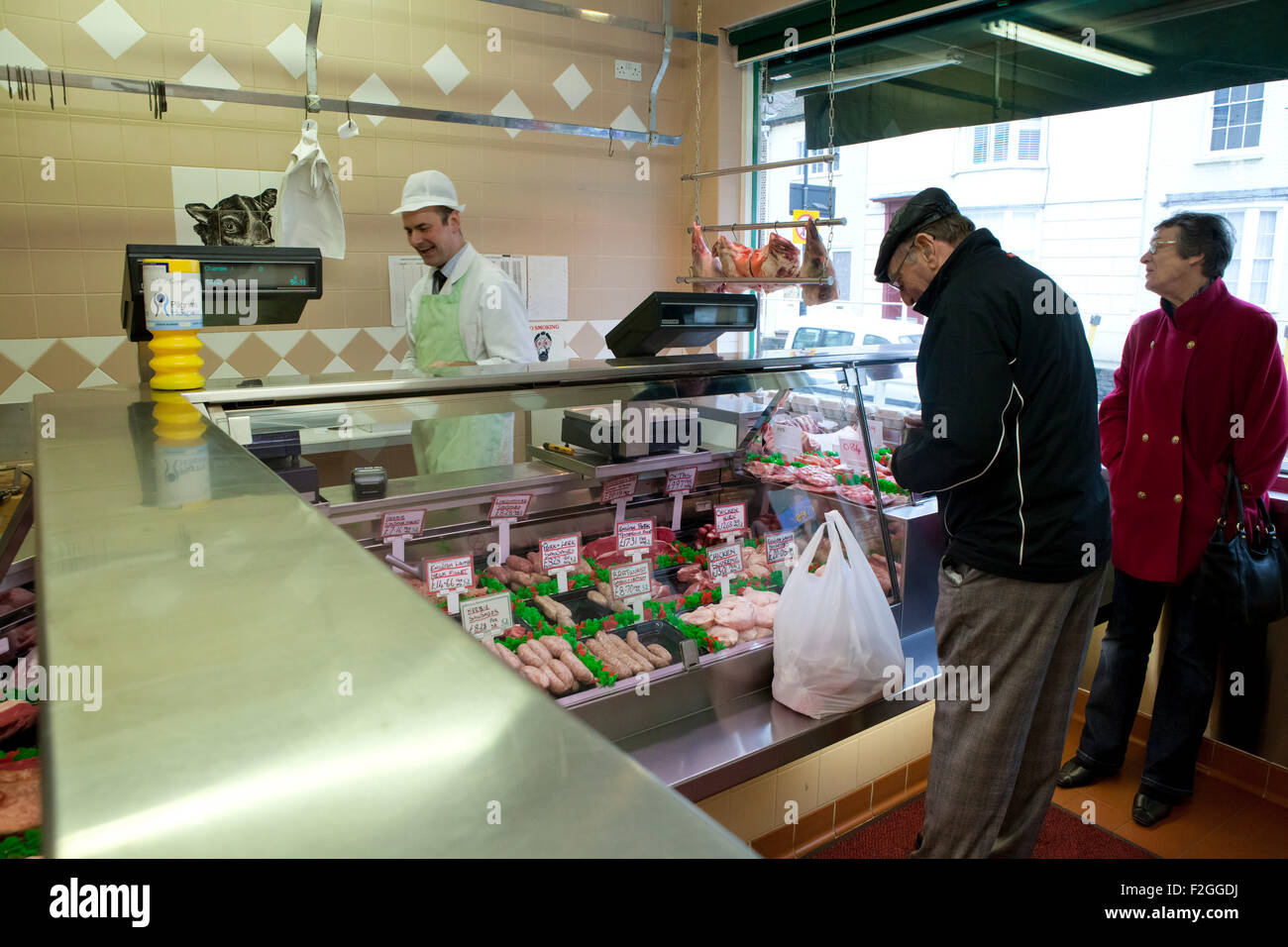 People inside a butcher's shop in Canterbury, Kent. Stock Photo