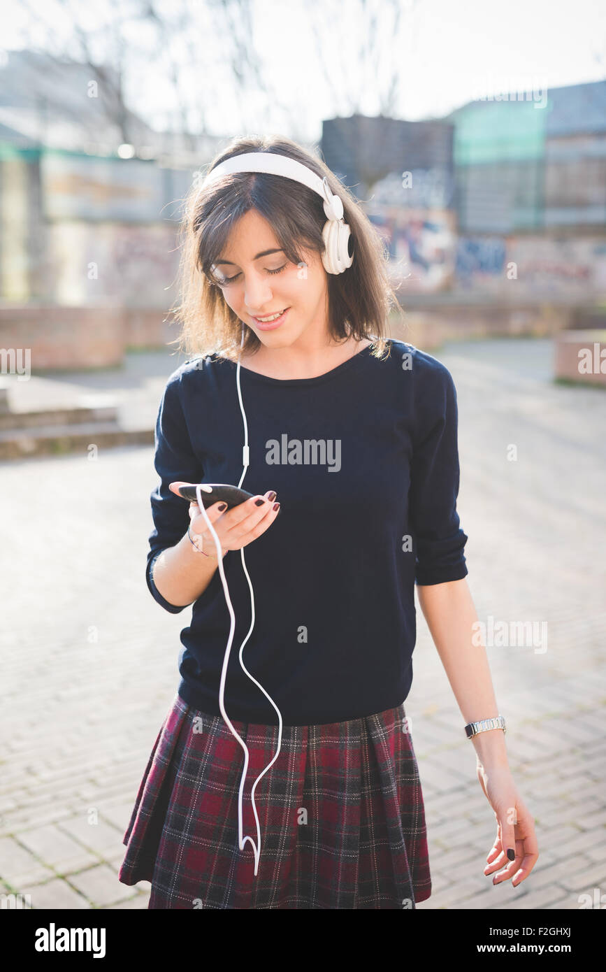 Knee figure of a young pretty brown hair caucasian girl listening music