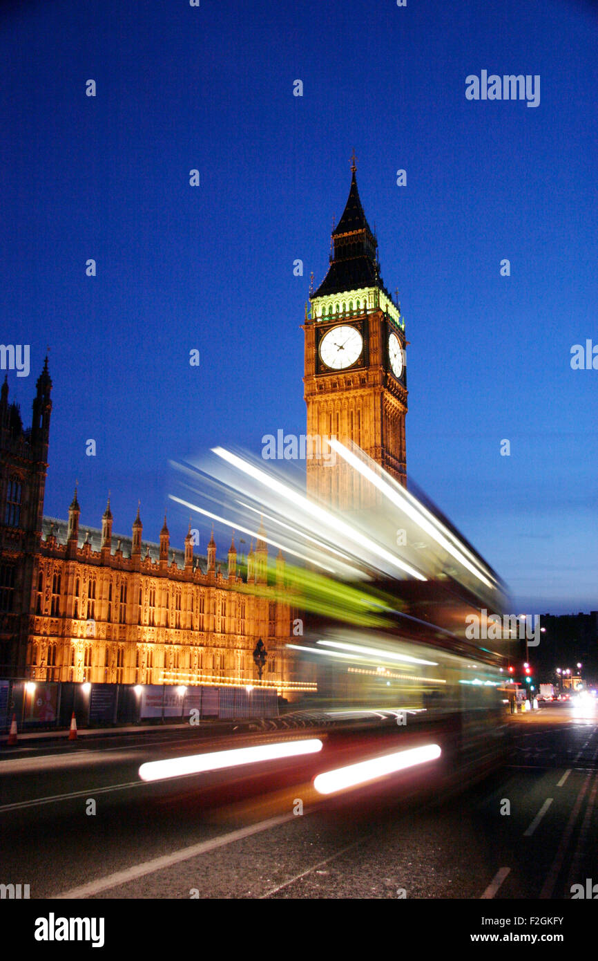 Traffic streams over Westminster Bridge at night leaving trails of light in front of Big Ben and the Houses of Parliament. Stock Photo