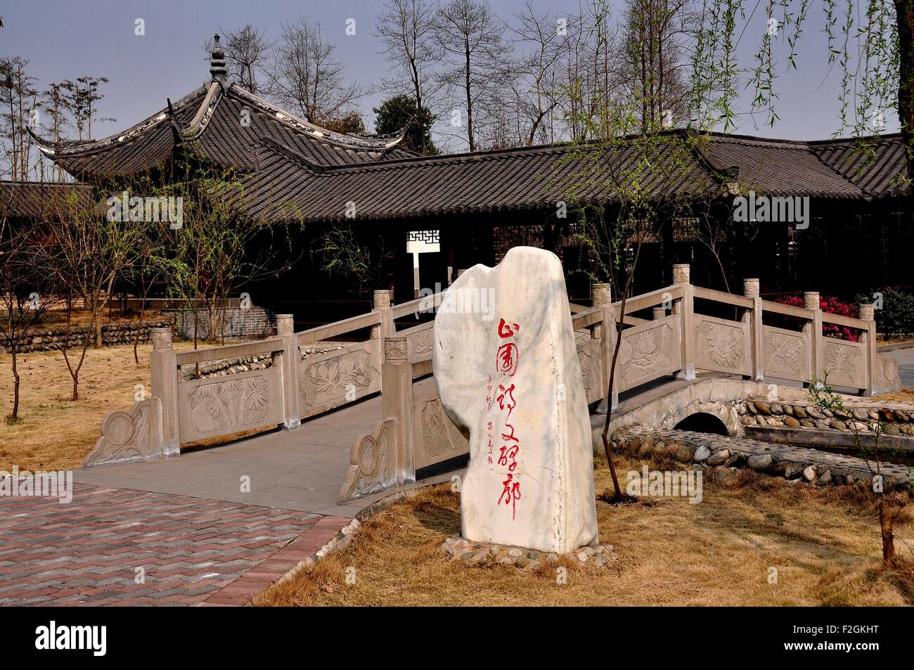 Sheng Pin, China:  Stone with Chinese characters and small footbridge in the gardens at the General Yin Chang He House Museum Stock Photo