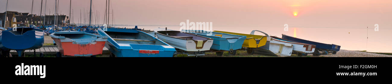 A panoramic view of a line of dinghys laid out on the beach at Whitstable Stock Photo