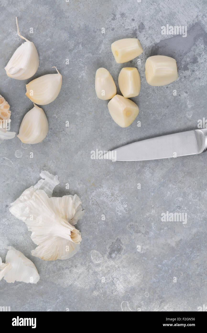 Garlic bulb and single cloves with silver knife on a cold modern metal background Stock Photo