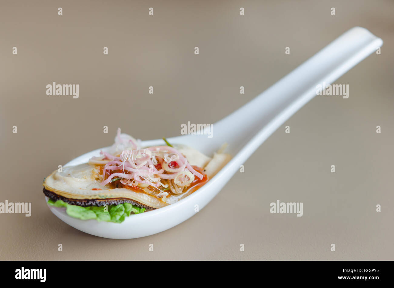 giant mussel with spicy chili sauce on spoon Stock Photo Alamy