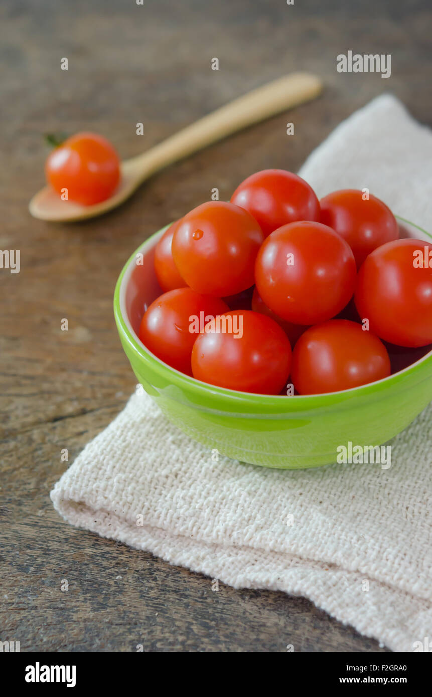 Red cherry tomatoes on a textured wooden background Stock Photo - Alamy