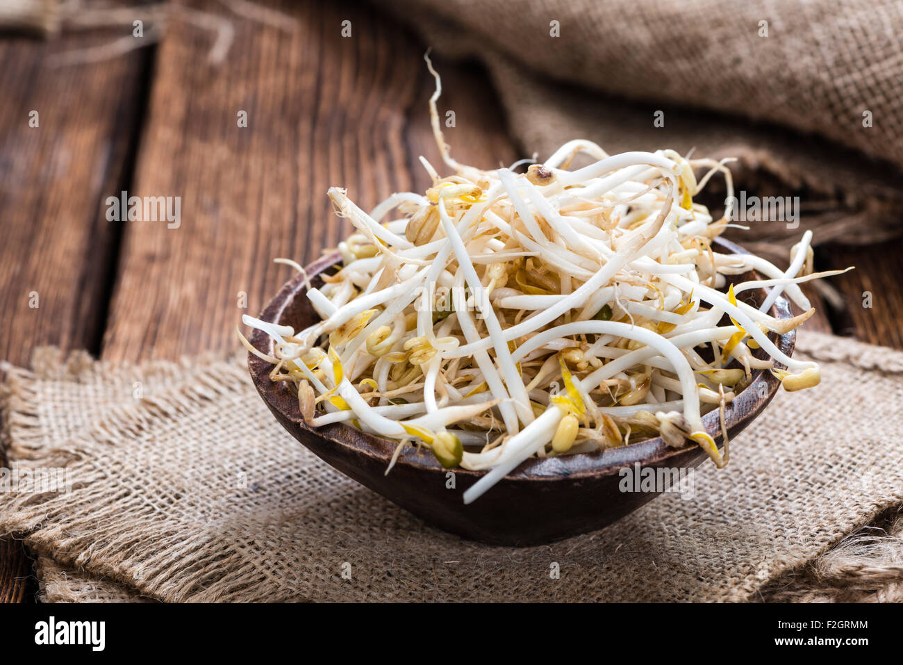 Bowl with Mungbean Sprouts on wooden background Stock Photo
