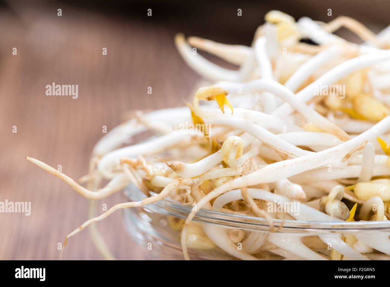 Bowl with Mungbean Sprouts on wooden background Stock Photo