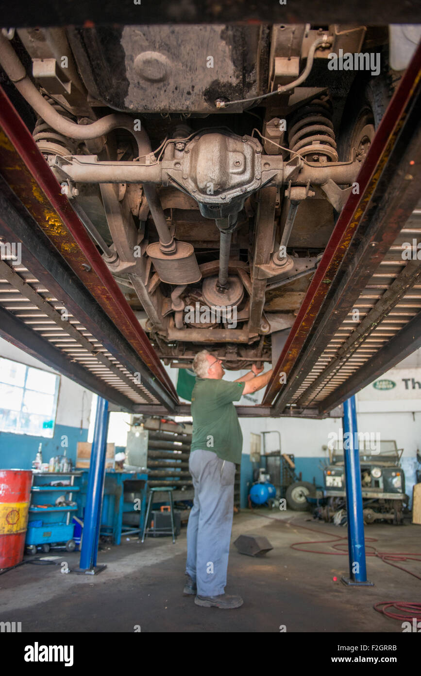 Auto Mechanic working under vehicle in his shop in Africa Stock Photo