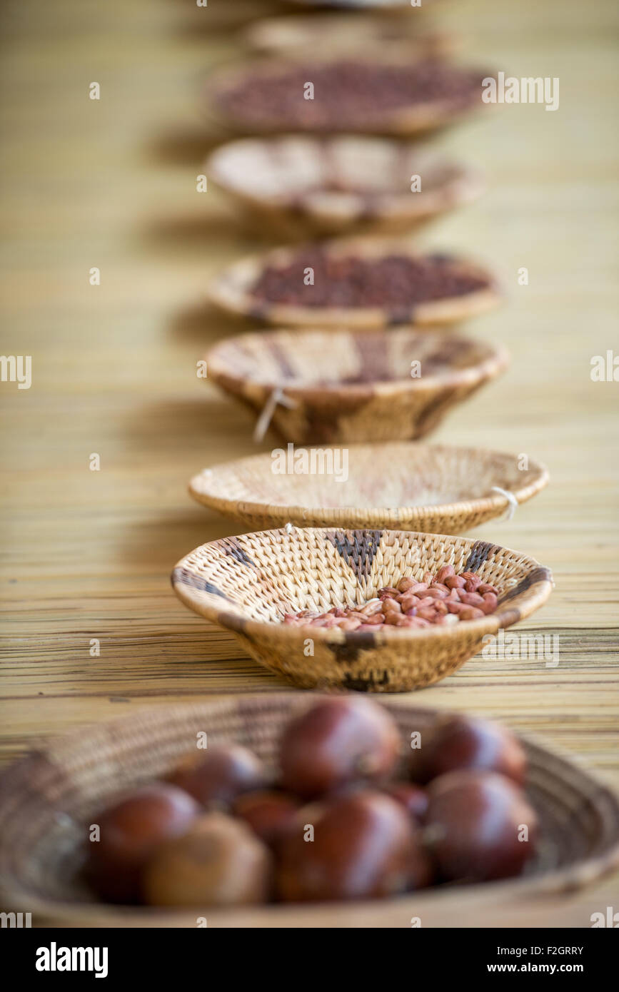 Row of dried food in handwoven bowls on a wicker mat in Botswana, Africa Stock Photo