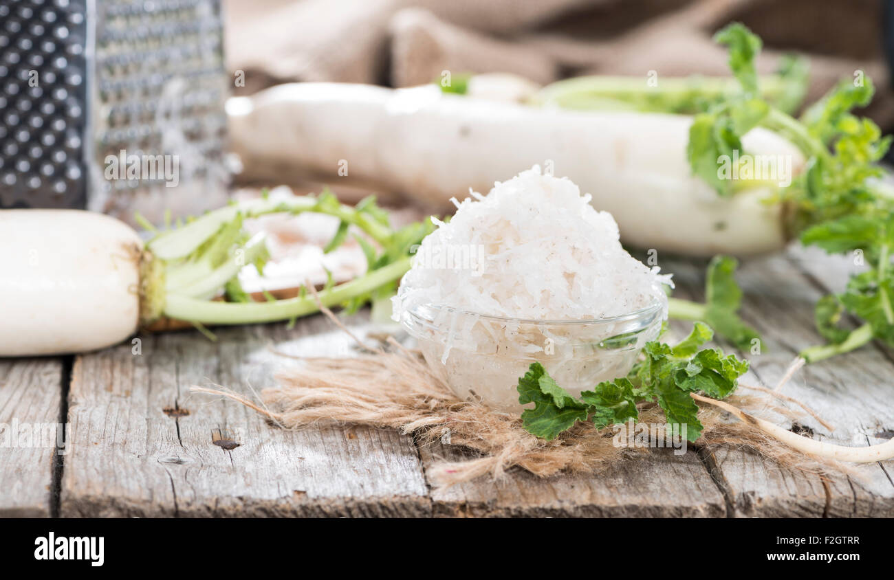 Fresh grated Horseradish on wooden background (detailed closeup shot
