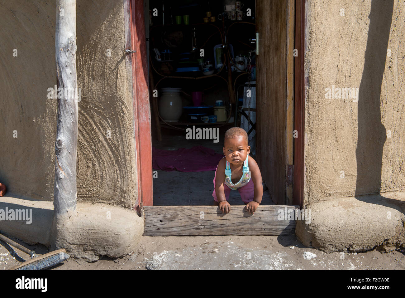 Small child looking through a doorway in Botswana, Africa Stock Photo