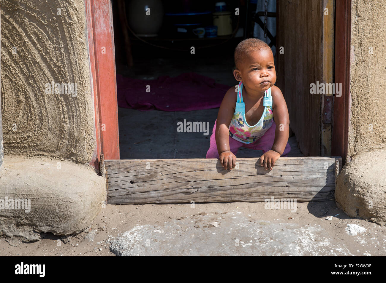 Small child looking through a doorway in Botswana, Africa Stock Photo