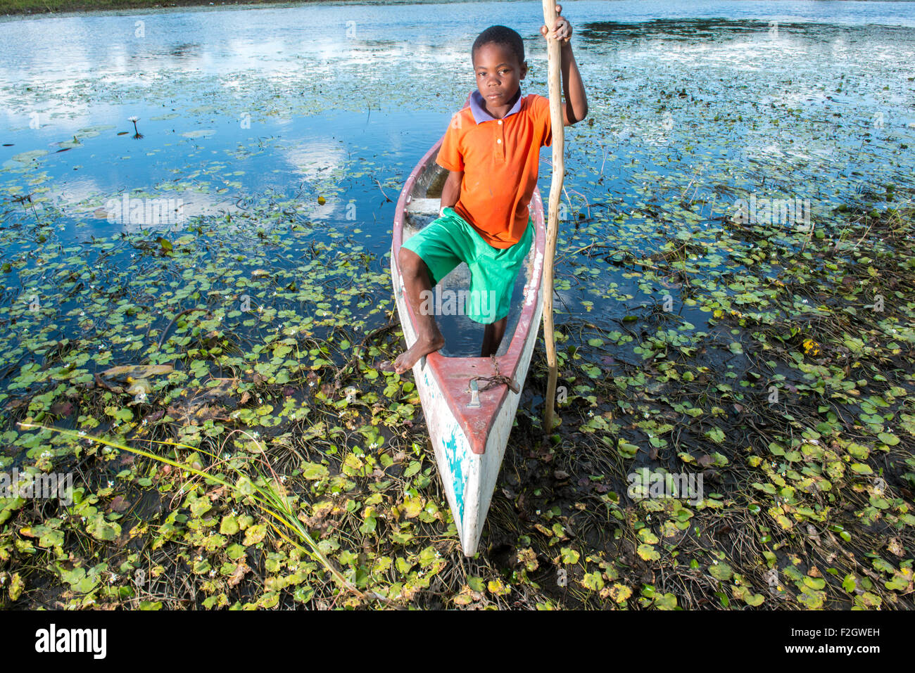 Boy standing up in Makoro on the Thamalakane River in Africa Stock Photo