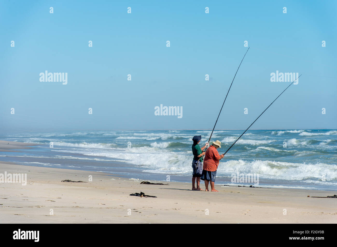 Two people fishing at the Cape Cross Seal Reserve on the Skeleton Coast in Africa Stock Photo