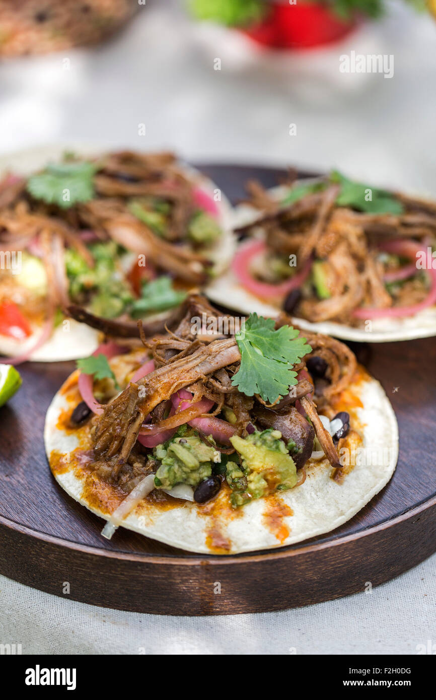 Three slowcooked beef brisket chili tacos (garnished with guacamole