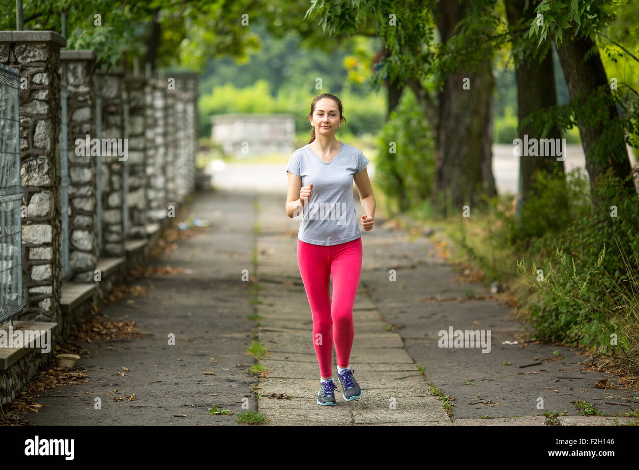 Young jogger girl running along the path in the Park Stock Photo Alamy