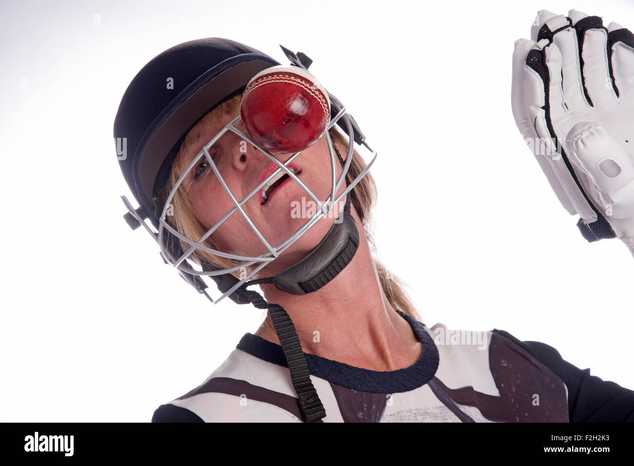 Cricketer wearing safety helmet being hit by a cricket ball Stock Photo