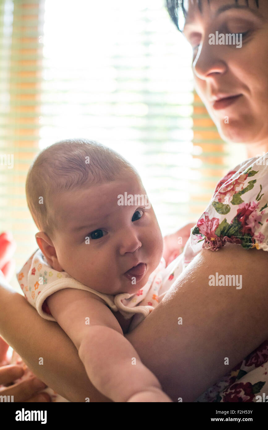 Baby and mom to the window. Backlight Stock Photo
