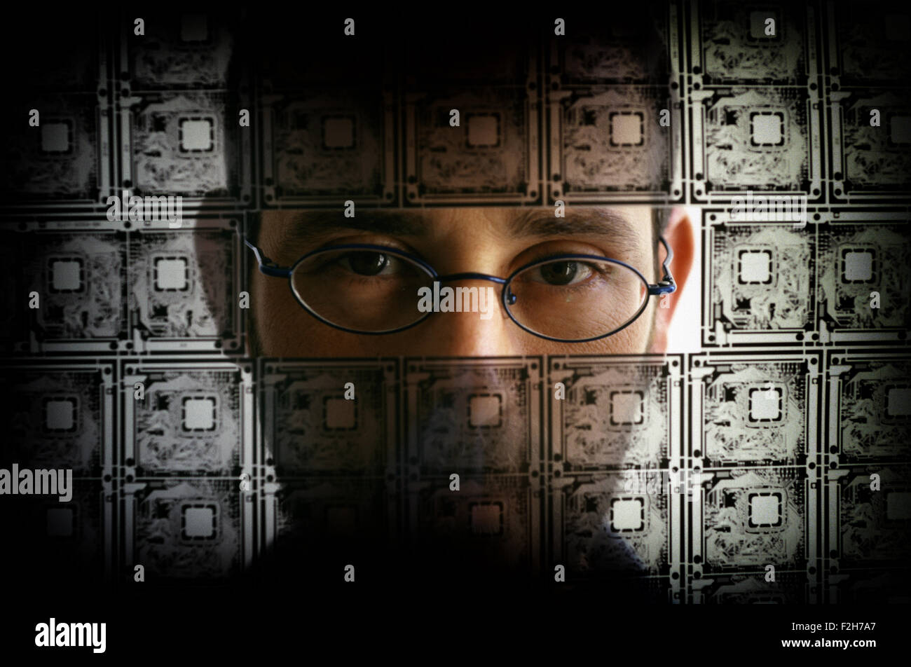 A person looking through transparent electric circuit board and barbed wire Stock Photo