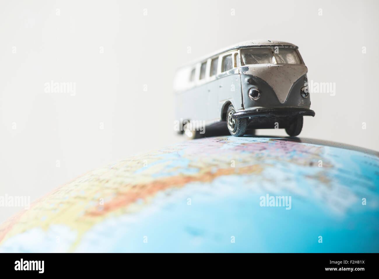 Vintage VW bus on globe. Miniature concept Stock Photo