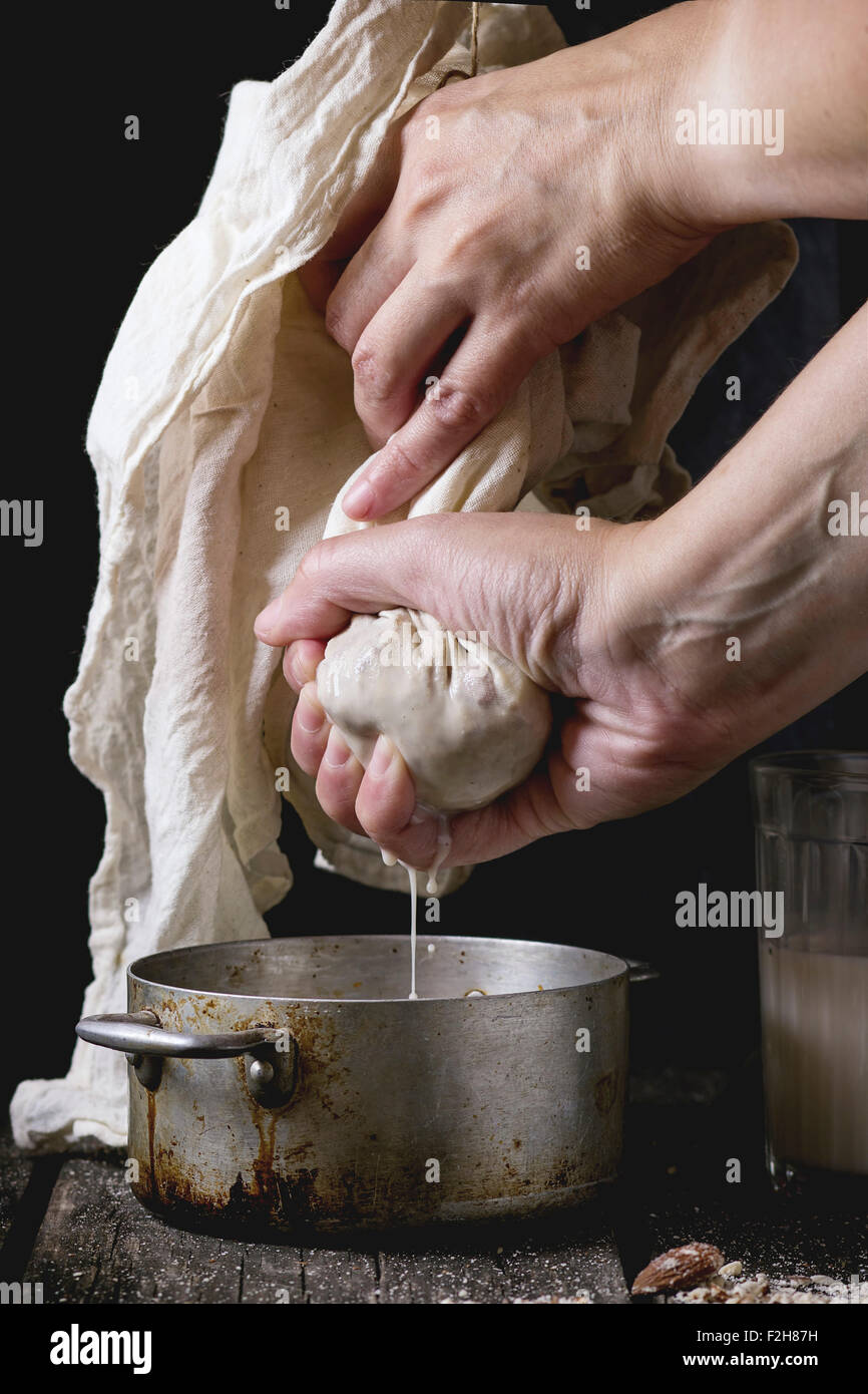 Process of making nondairy almond milk woman's hands extracting milk