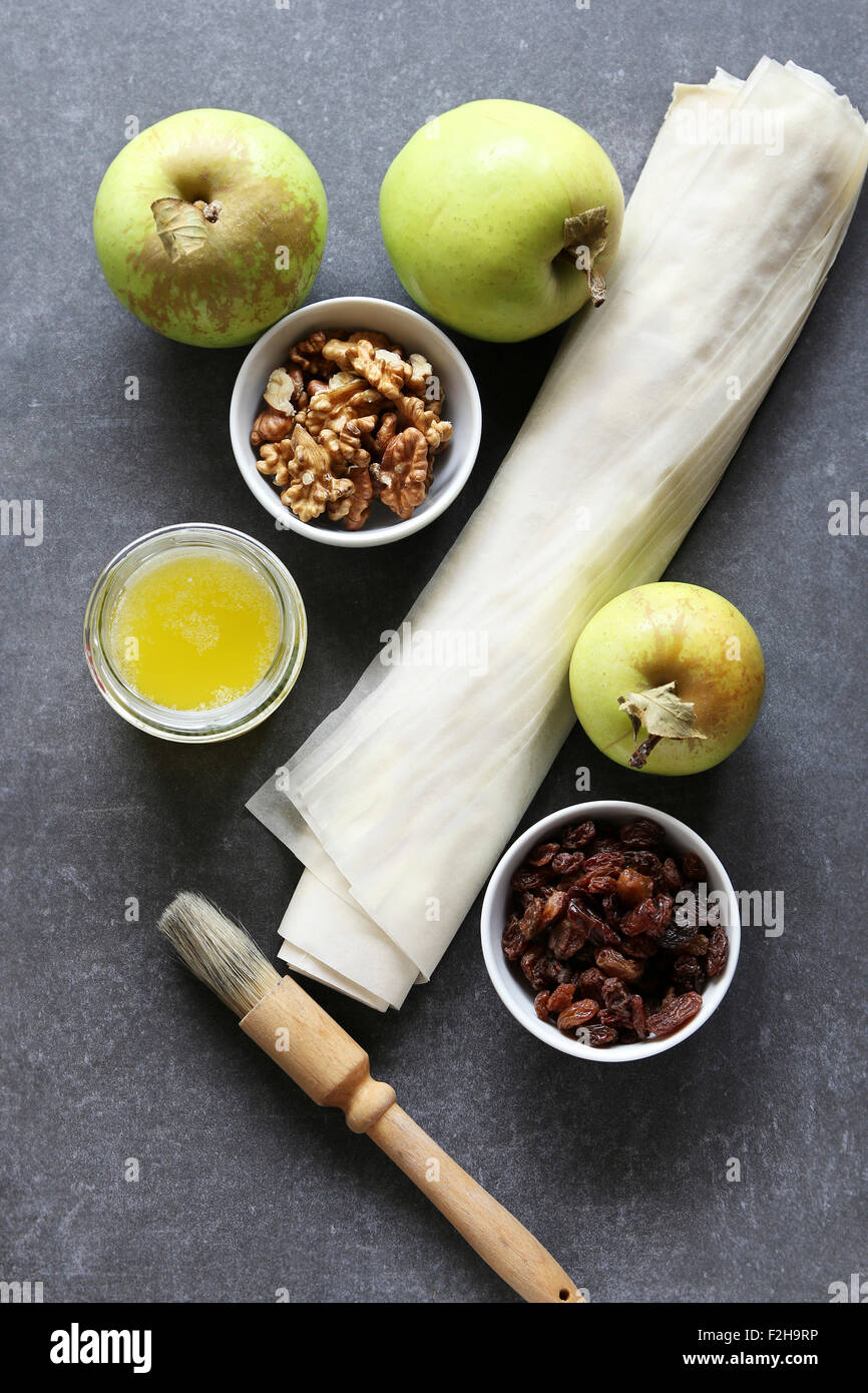 Ingredients for making apple strudel.Apple,raisins,walnuts,filo pastry and butter Stock Photo