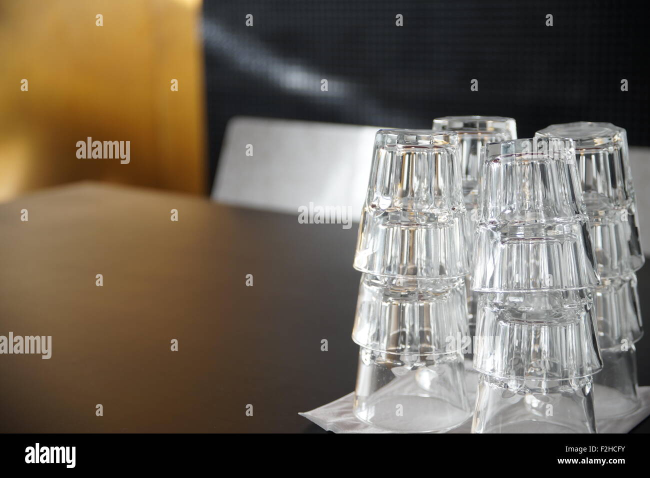 Clean drinking glasses stacked on a black table in a cafe. Stock Photo