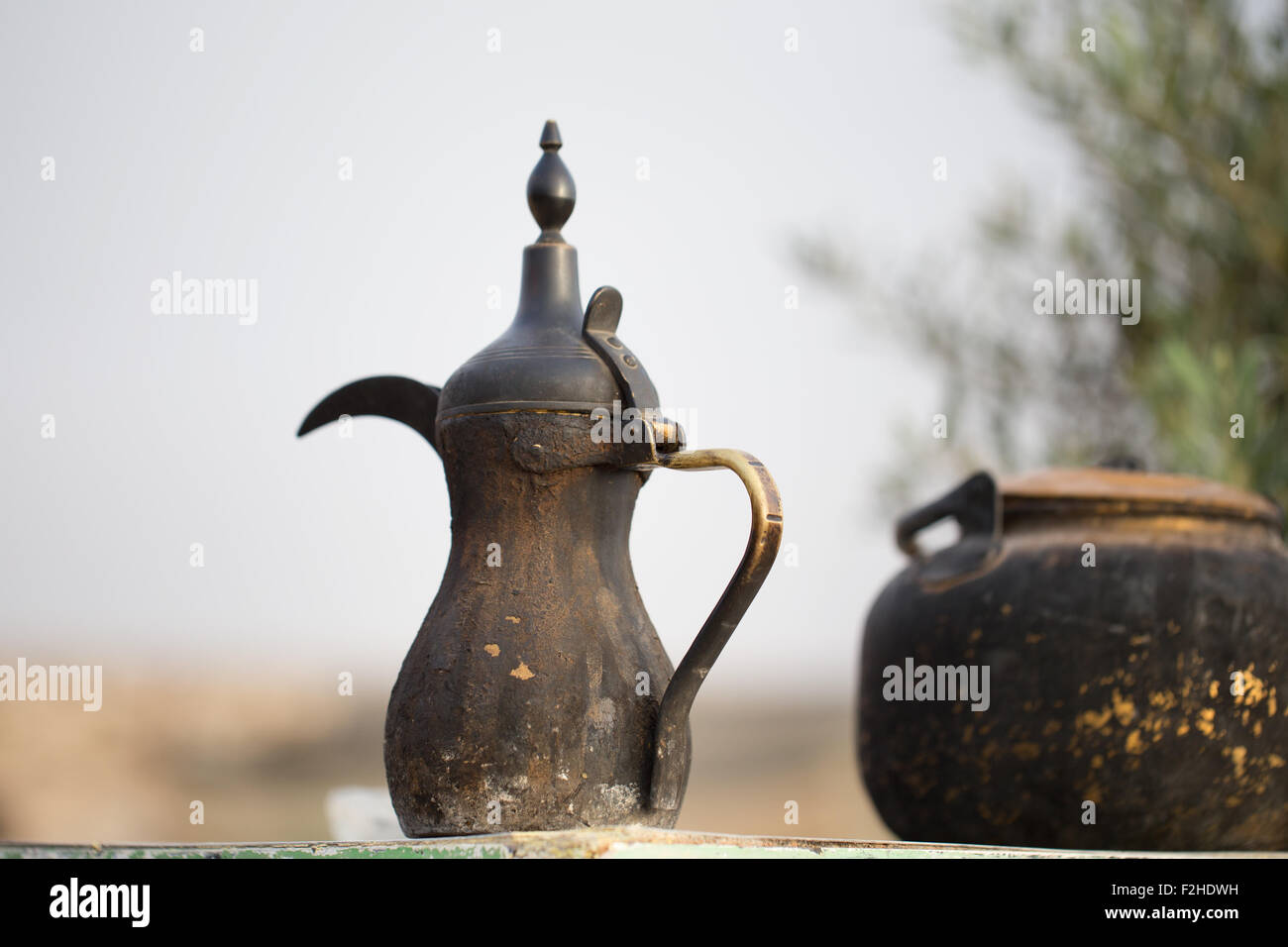 Traditional vintage arabian old smoked coffee maker, in Bedouins camp. Put on the old table. With vintage tea maker. Stock Photo