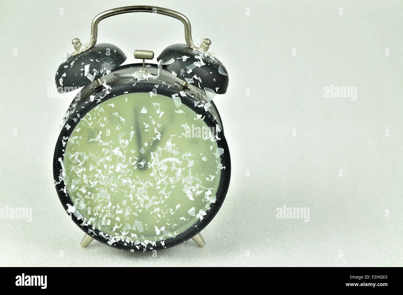 close up of a snowy black retro alarm clock, showing winter time, 1 am