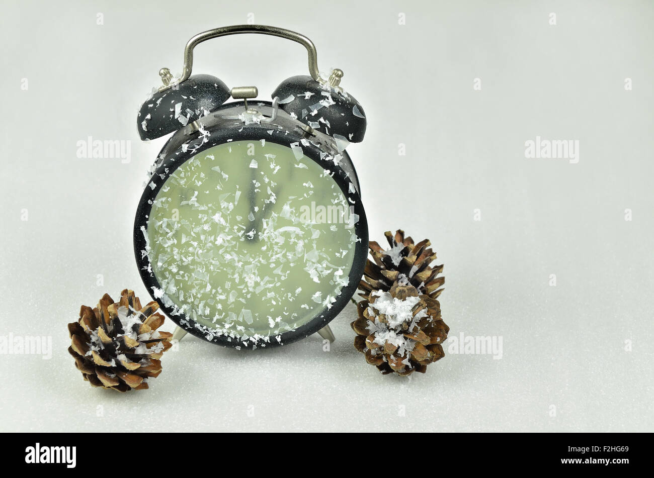 close up of a snowy black retro alarm clock, showing winter time, 1 am
