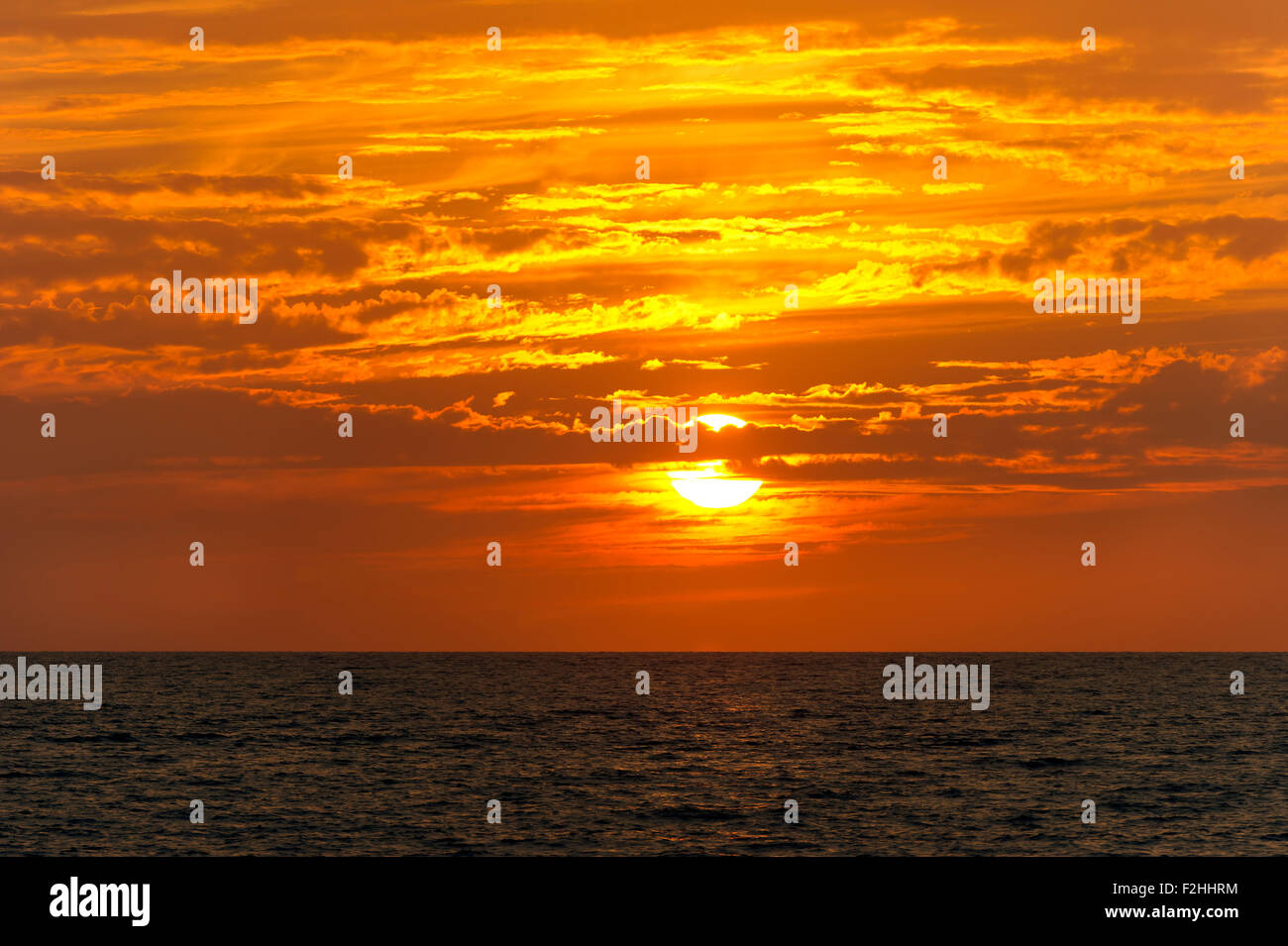 Sunset clouds ocean is a bright orange and yellow cloudscape with the ...