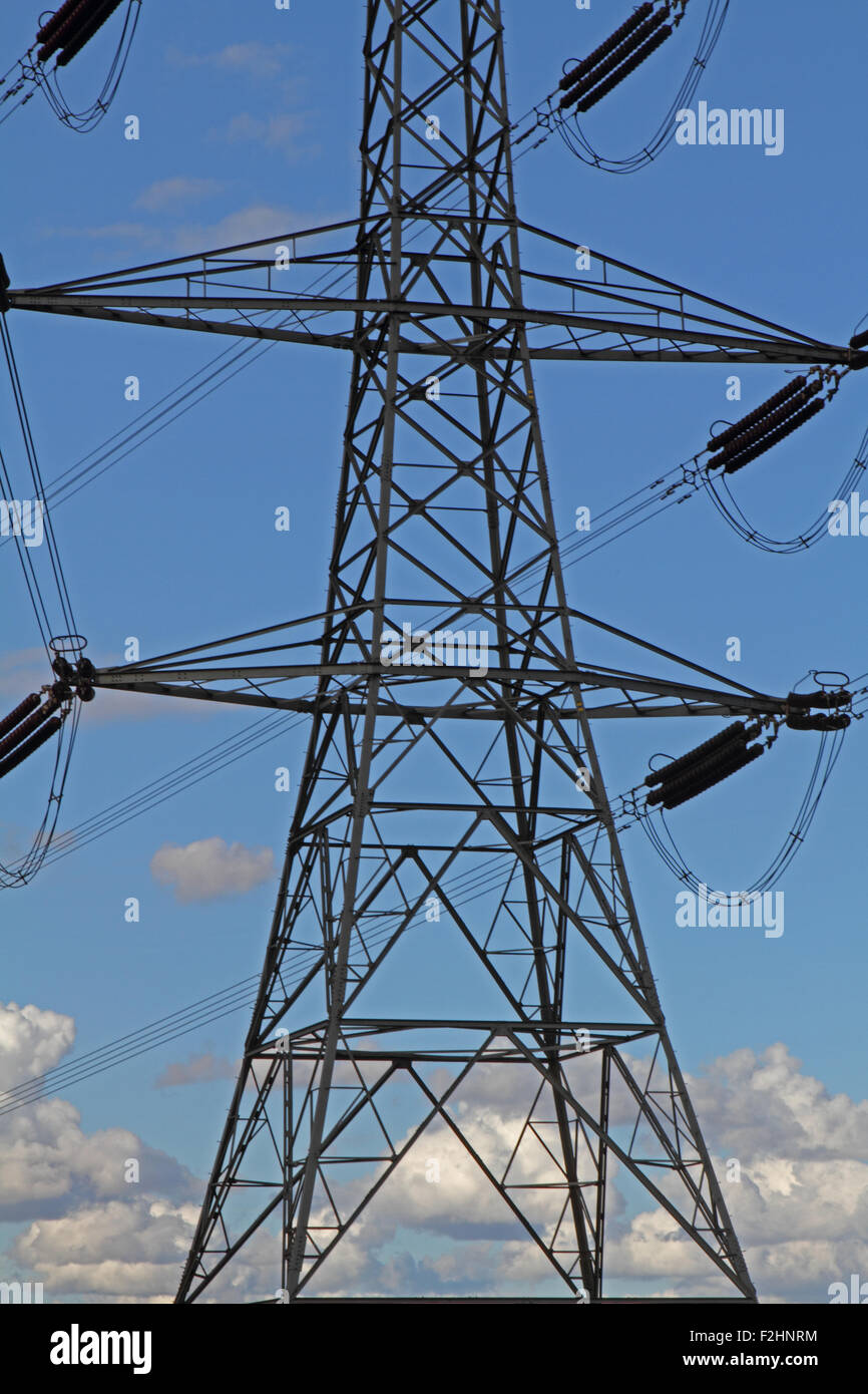 Electricity pylons against a cloudy blue sky Stock Photo