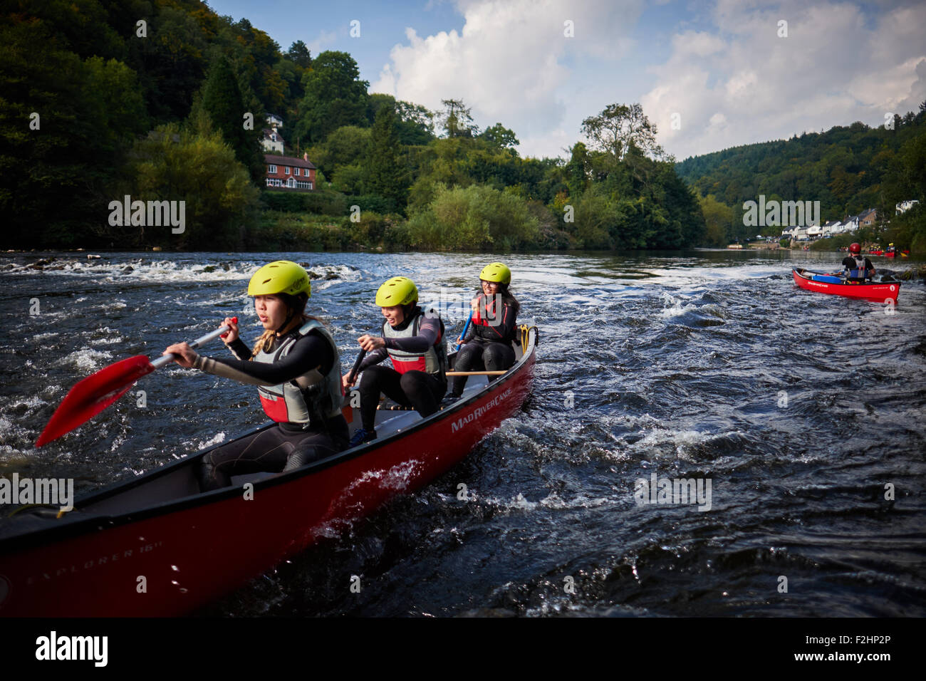 Three young people canoeing down Symonds Yat on the river Wye in Wales