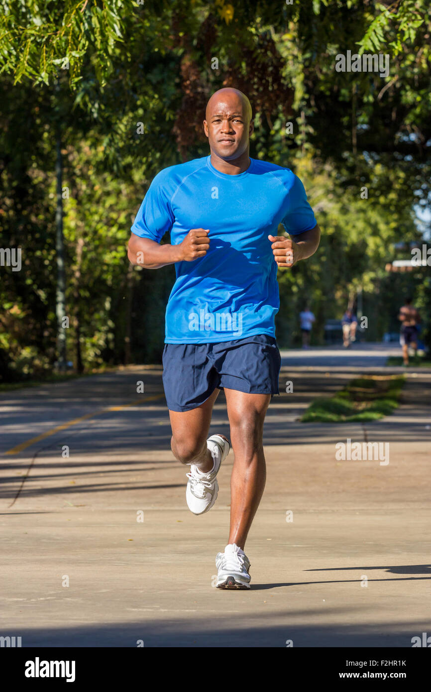 Young African-American black man jogging and running on a path and