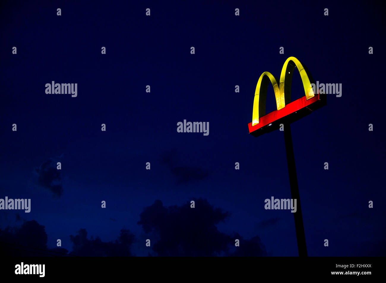 A logo sign outside of a McDonald's Fast Food restaurant at night in Round Rock, Texas on September 11, 2015. Stock Photo