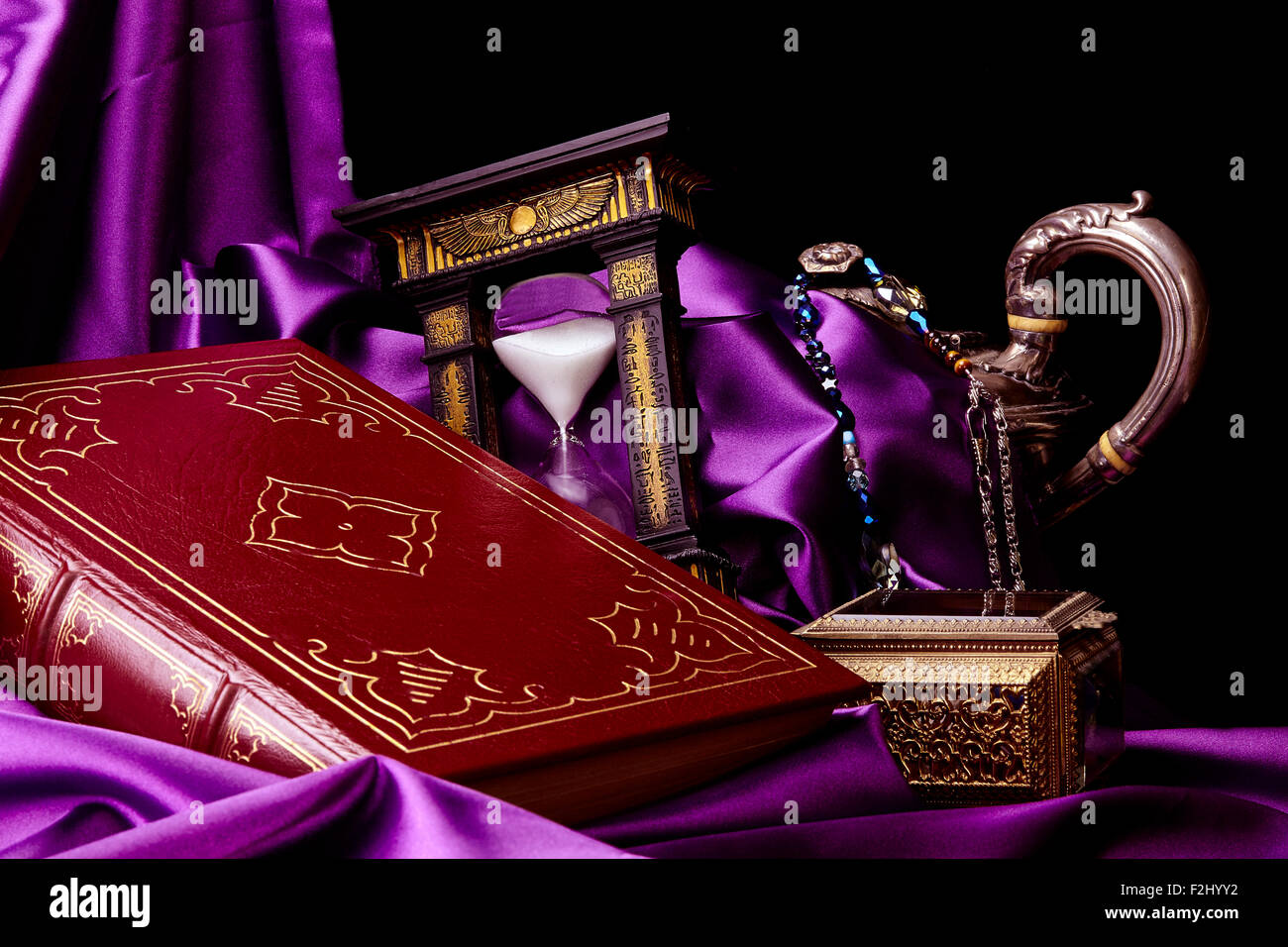 Closed Ancient Book with Treasures on Satin Stock Photo
