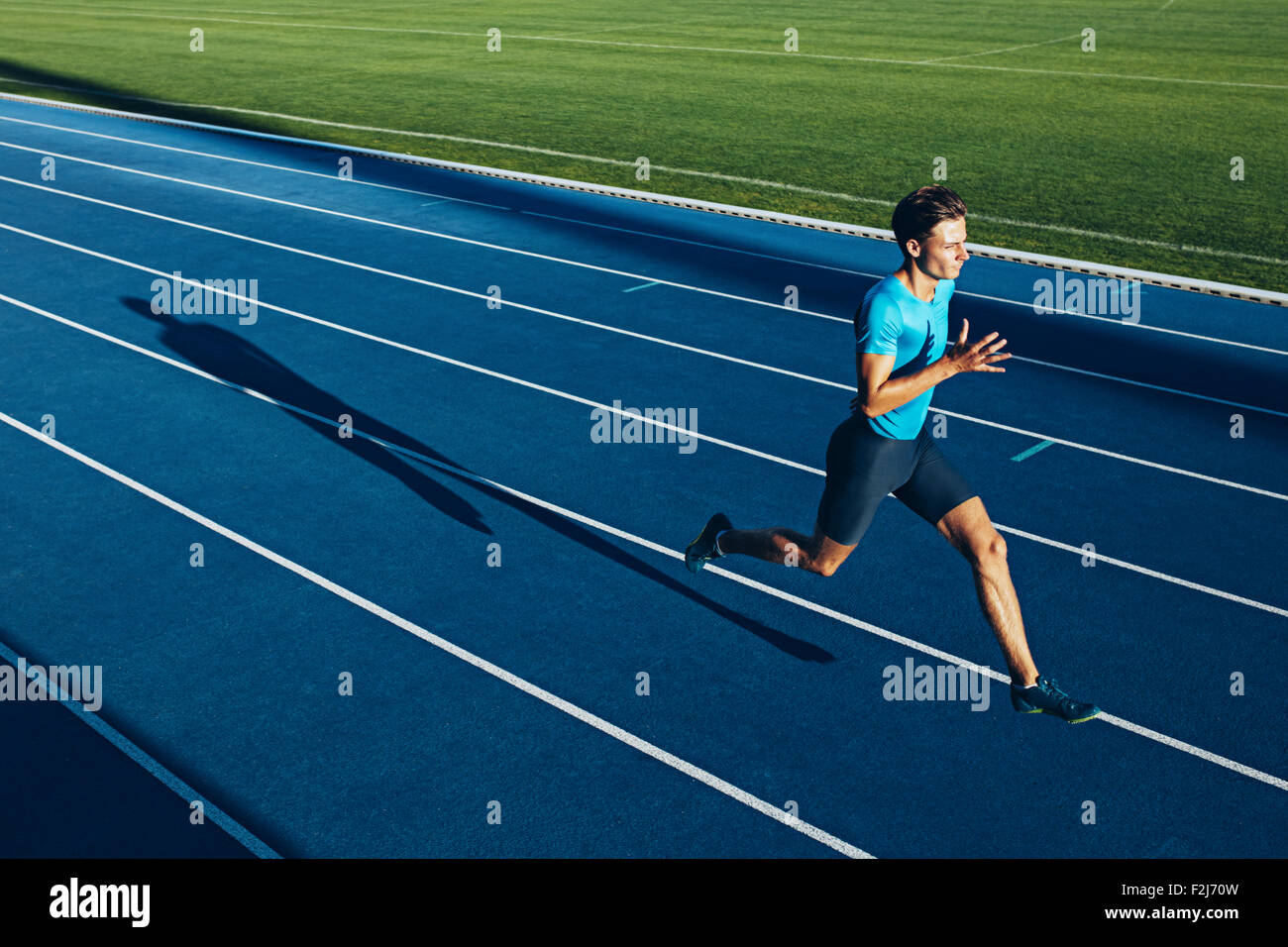 Shot of a young male athlete training on a race track. Sprinter running on athletics tracks. Stock Photo