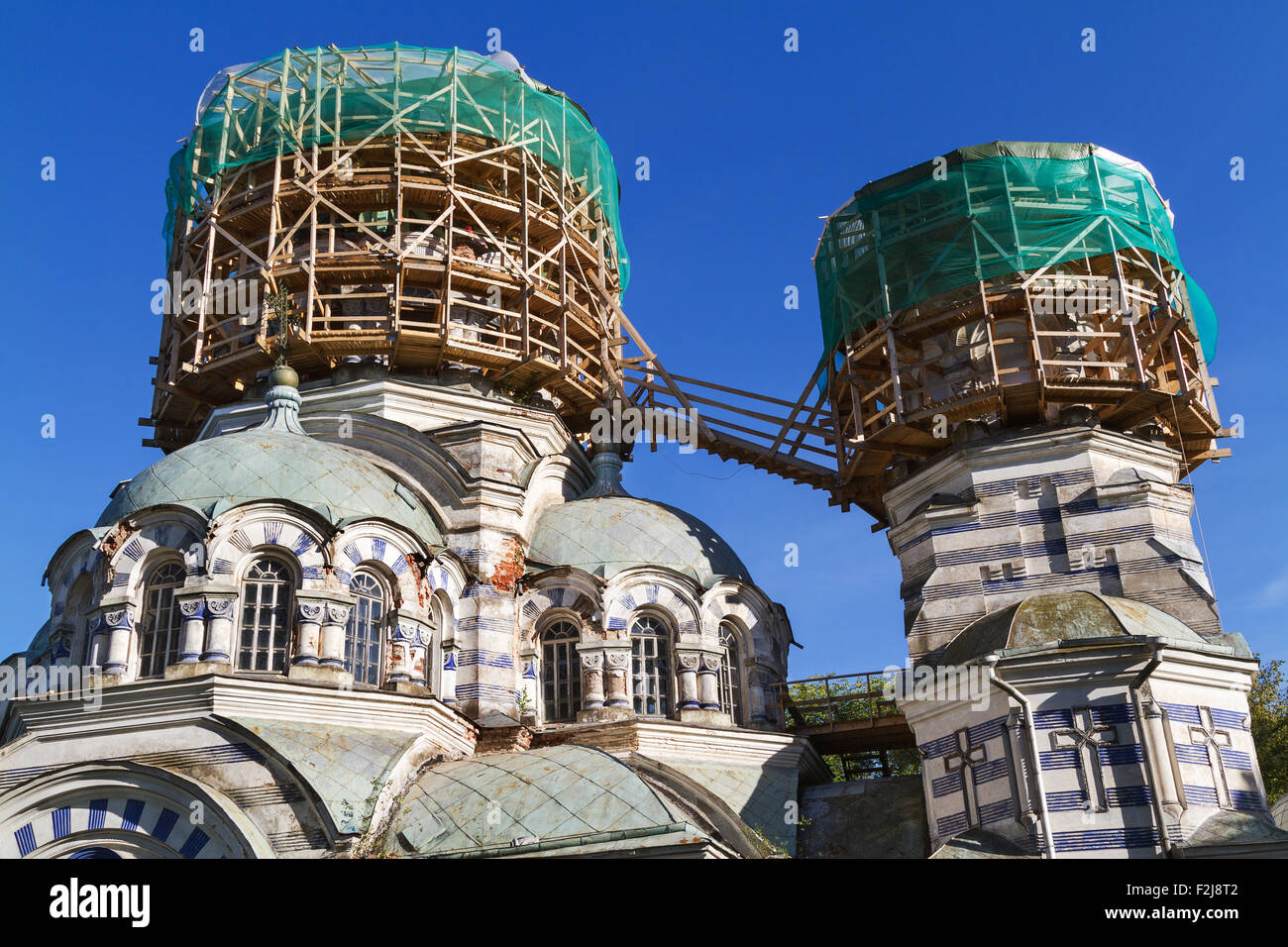 Two domes of the Russian orthodox church in scaffolding round shape, against the blue sky Stock Photo