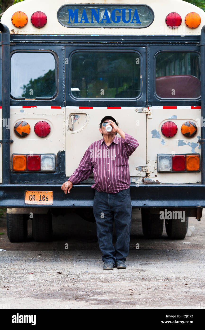A bus driver takes a break and drinks a refreshing beer at the tope or horse parade in Granada, Nicaragua Stock Photo