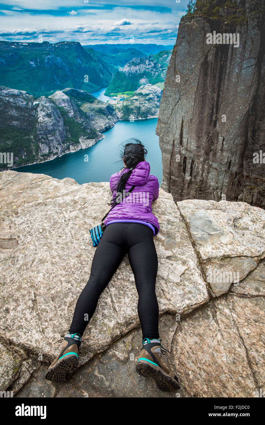 Woman looking at the landscape from a height. Beautiful Nature Norway Preikestolen or Prekestolen. Stock Photo
